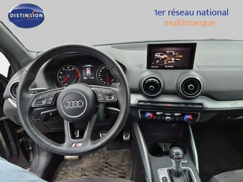 Vue intérieure de l'Audi Q2 1.4 TFSI S line 2017, tableau de bord et volant sport en cuir noir.
