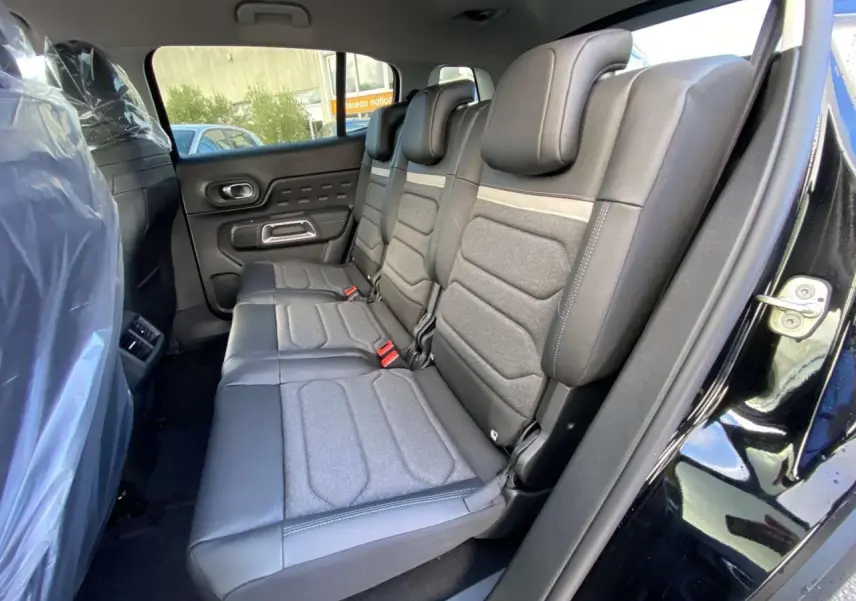 Vue latérale droite des sièges arrière en cuir et tissu gris du Citroën C5 Aircross noir perla 2025, porte ouverte.