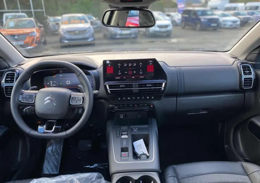 Vue intérieure du tableau de bord et volant du Citroën C5 Aircross 2025, avec écran tactile et sellerie noire.