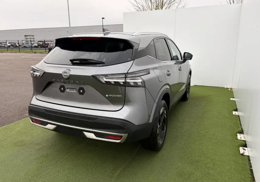 Vue 3/4 arrière droite du Nissan Qashqai III 1.5 Hybrid e-Power gris foncé métallisé avec badges e-POWER visibles.