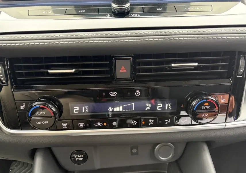 Vue rapprochée de la console centrale du Nissan Qashqai III 2025, affichant la climatisation automatique bi-zone et commandes chauffantes.