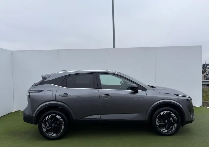 Vue de profil côté gauche du Nissan Qashqai III 1.5 Hybrid e-Power gris foncé métallisé avec jantes alliage noires.