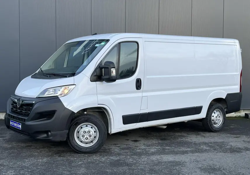 Vue 3/4 avant droit d’un fourgon Opel Movano blanc avec pare-chocs noirs et porte latérale coulissante.