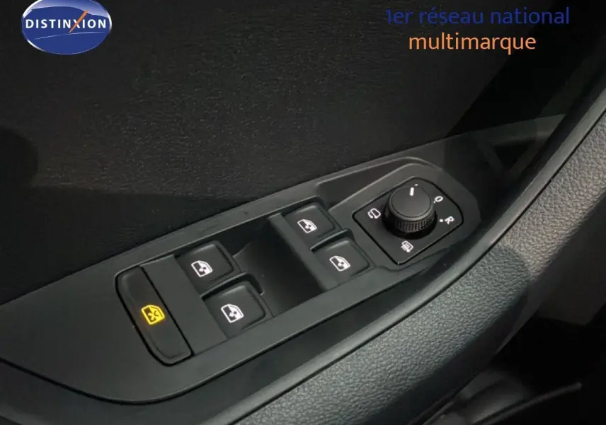 Gros plan sur les commandes des vitres électriques et des rétroviseurs côté conducteur d’un Skoda Karoq gris argent 2025.