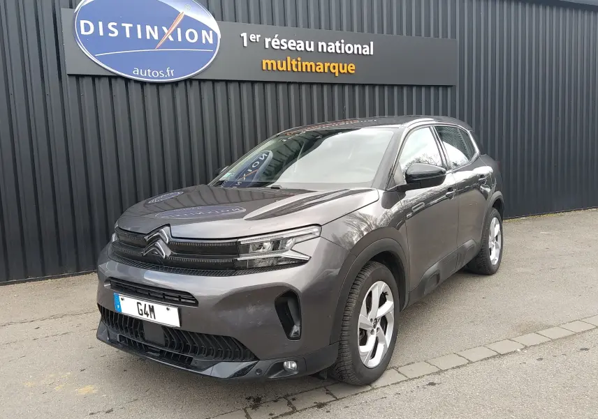 Vue 3/4 avant droit d'un Citroën C5 Aircross gris métallisé avec calandre distinctive et jantes alliage cinq branches.