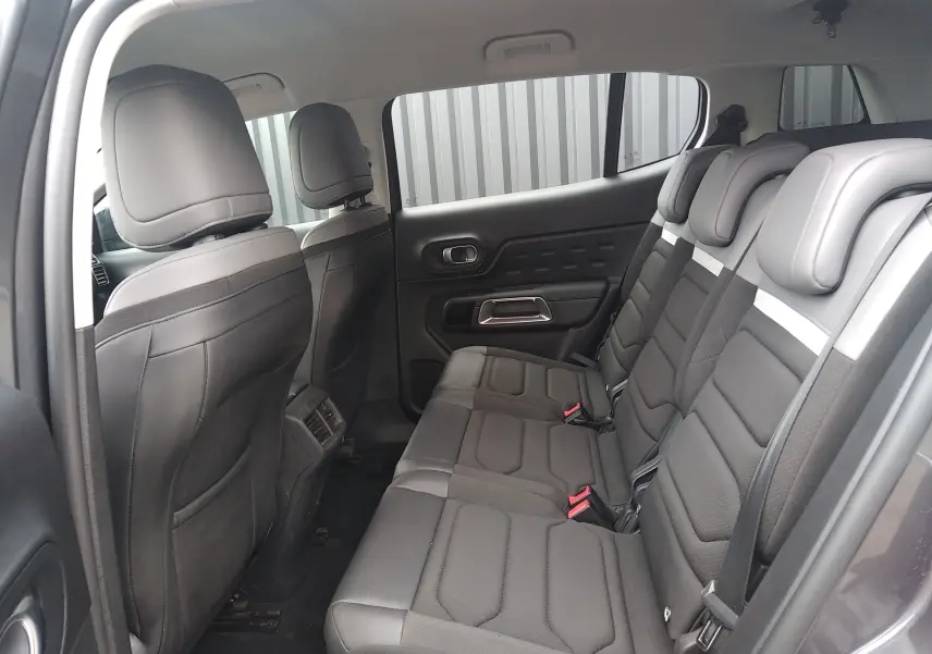Vue intérieure côté gauche des sièges arrière noirs en tissu et cuir du Citroën C5 Aircross 2023, version Feel diesel.
