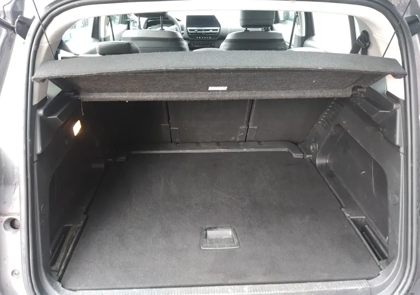 Coffre ouvert vu de l'arrière d'un Citroën C5 Aircross gris, avec cache-bagages et intérieur noir visible.