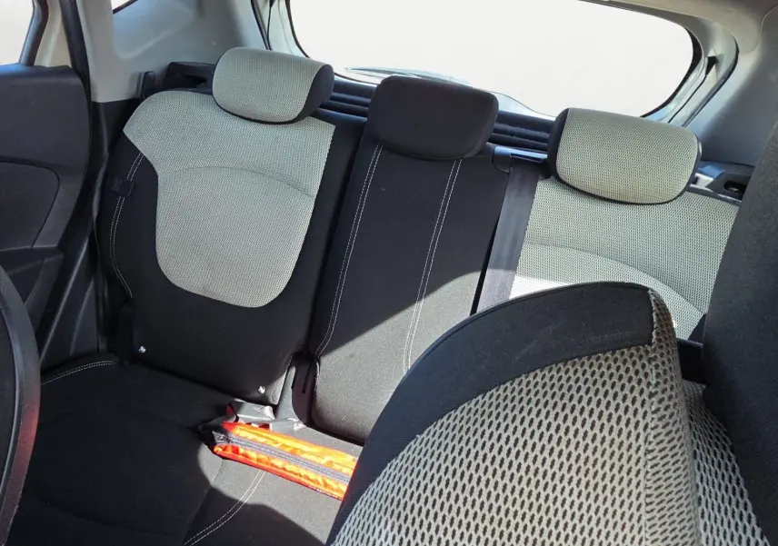 Vue intérieure arrière du Renault Captur 1.5 dCi 2018, sièges bicolores ivoire et noir avec appuie-têtes.