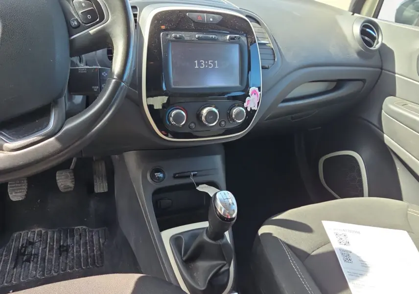 Vue intérieure centrée sur la console centrale et levier de vitesse manuel d’un Renault Captur ivoire de 2018.