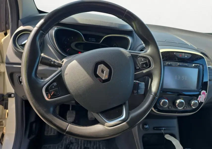 Vue rapprochée du volant en cuir noir et du tableau de bord du Renault Captur ivoire, version 2018 diesel.