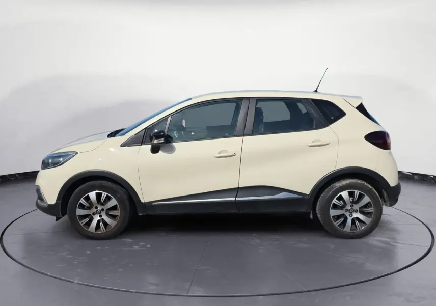 Renault Captur 1.5 DCI 90 Business ivoire vu de profil côté gauche avec jantes alliage et protections noires.