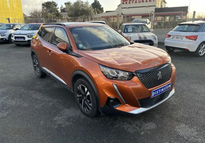Peugeot 2008 orange fusion vue 3/4 avant droit, avec calandre noire et jantes alliage noires et argentées.