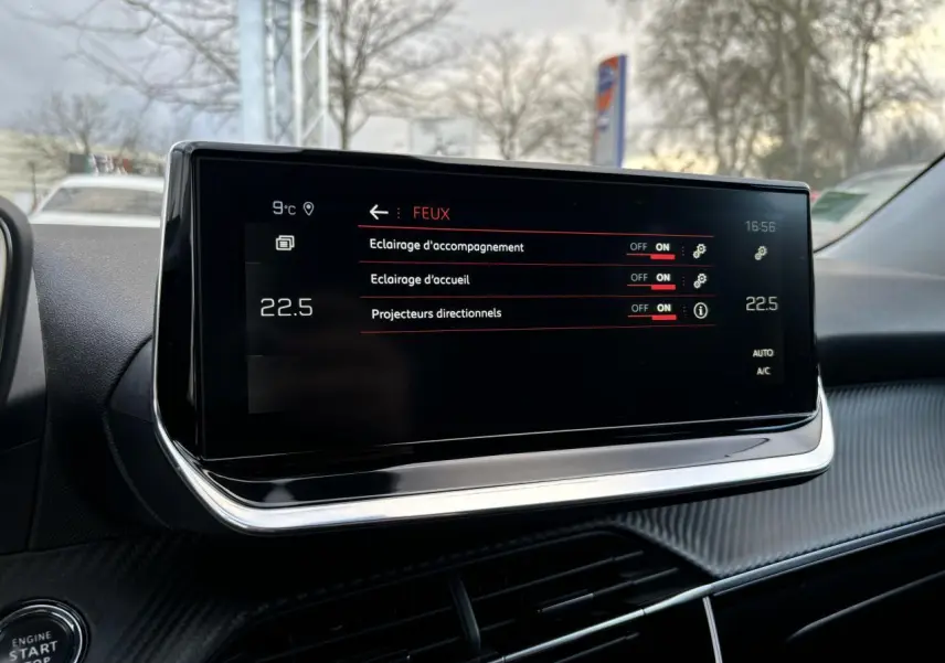 Écran tactile central du Peugeot 2008 2021 affichant les réglages des feux, avec tableau de bord noir et détails chromés.