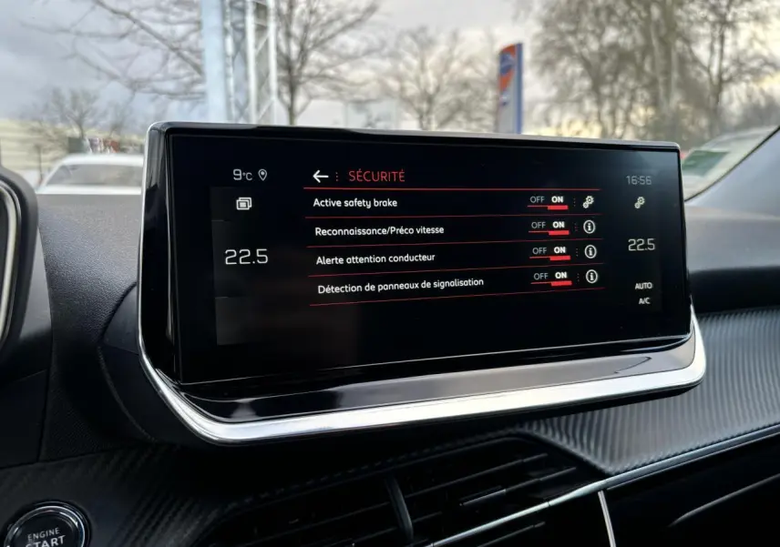 Écran tactile central du Peugeot 2008 2021 affichant les options de sécurité, avec tableau de bord noir et détails carbone.