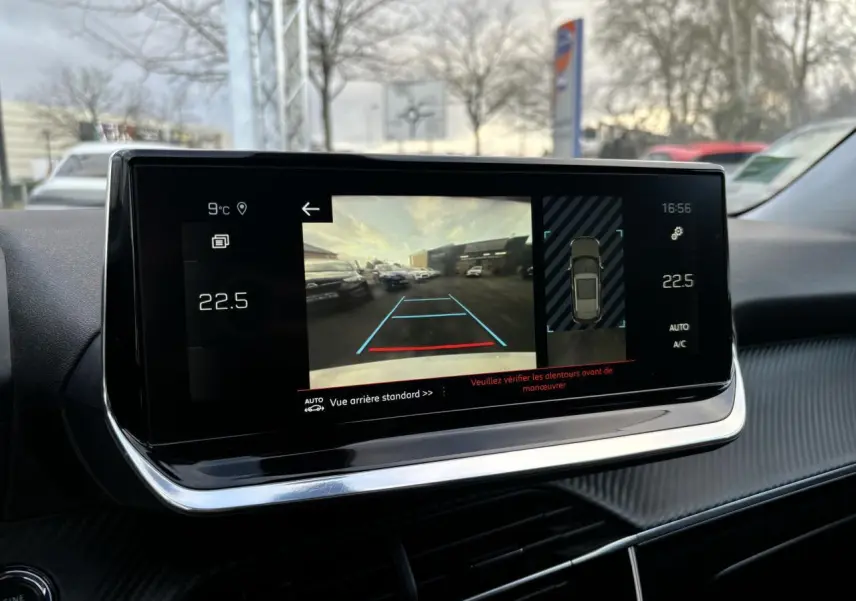 Écran tactile intérieur du Peugeot 2008 affichant la caméra de recul et l'aide au stationnement en journée.