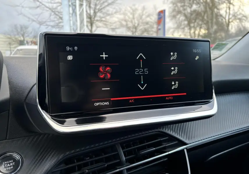 Écran tactile 10 pouces du tableau de bord du Peugeot 2008 affichant la climatisation à 22,5°C en extérieur urbain.