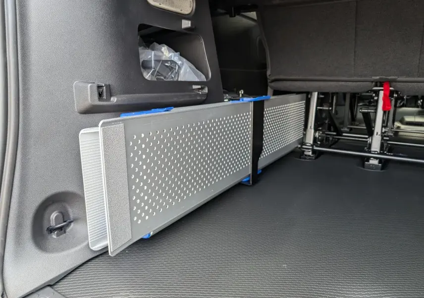 Détail intérieur montrant la rampe amovible en aluminium ajouré du Renault Trafic Fourgon gris, version 2024.