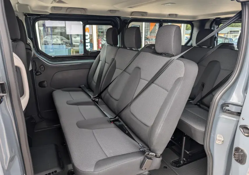 Vue intérieure côté droit sur les sièges tissu gris Kompo Black du Renault Trafic Fourgon L2 2024 avec ceintures attachées.