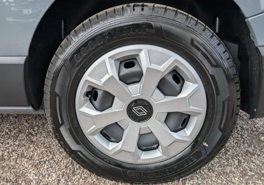 Gros plan sur la roue arrière droite du Renault Trafic Fourgon gris Urban 2024, montrant le pneu et l'aile du véhicule.