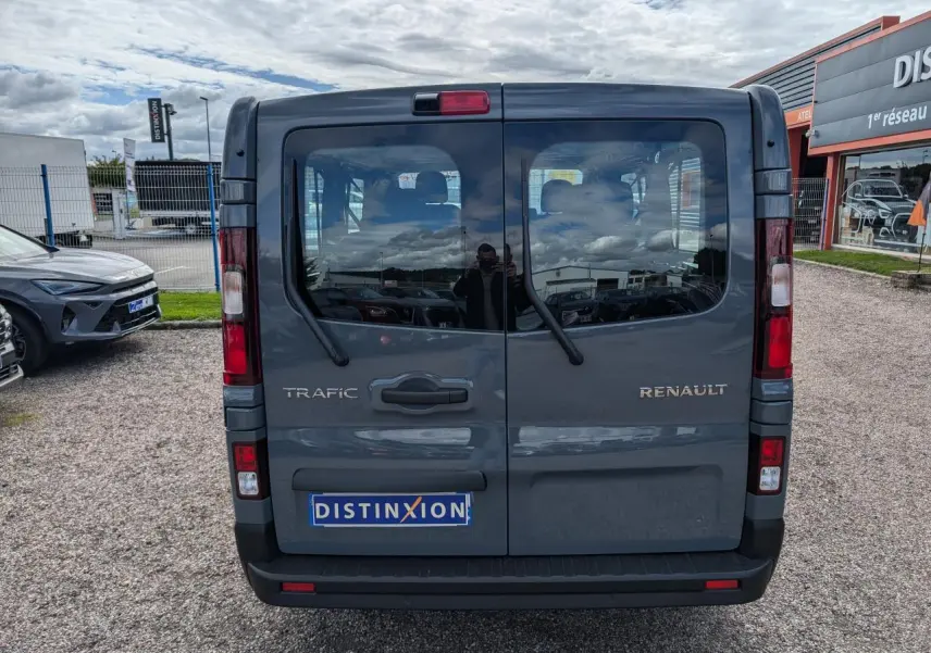 Vue arrière du Renault Trafic Fourgon gris avec portes vitrées et essuie-glaces sur chaque vantail.