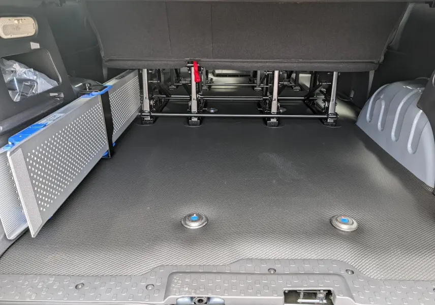 Espace de chargement arrière du Renault Trafic Fourgon gris 2024 avec rampe amovible Easy Access sur le côté gauche.