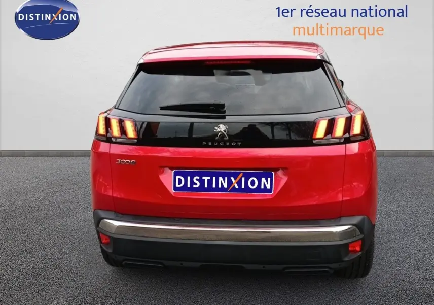 Vue arrière d'un Peugeot 3008 rouge foncé métal avec feux arrière allumés et logo Peugeot visible.
