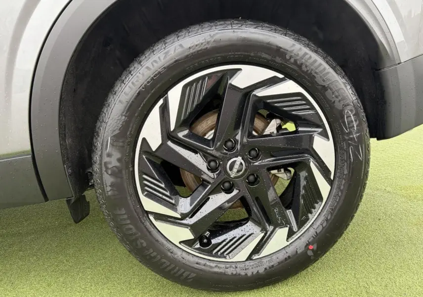 Gros plan sur la jante alliage 18 pouces bicolore noire et argent du Nissan Qashqai III gris foncé.