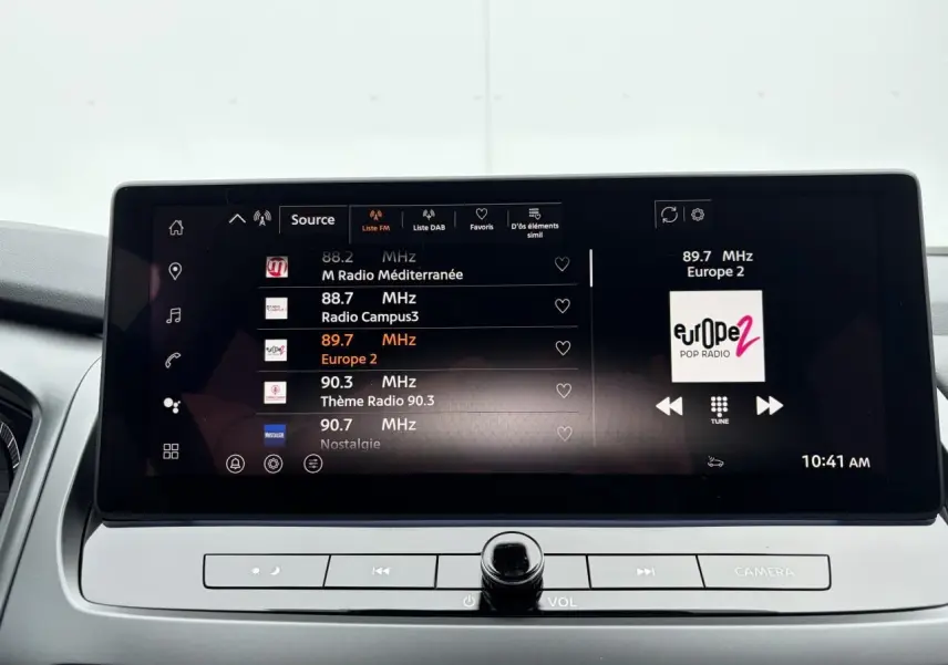 Écran tactile central du Nissan Qashqai 2025 affichant les stations radio, avec commandes intégrées en dessous.