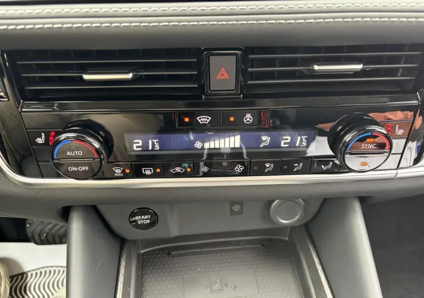 Vue rapprochée de la console centrale du Nissan Qashqai 2025, avec commandes climatisation bi-zone et bouton start/stop.
