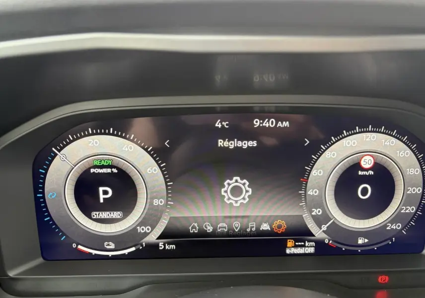 Affichage numérique du tableau de bord du Nissan Qashqai 2025, avec compte-tours et vitesse en km/h à l'arrêt.