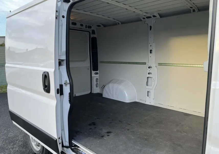 Vue latérale gauche d’un Opel Movano Fourgon blanc 2024 avec porte coulissante ouverte dévoilant l’espace de chargement vide.