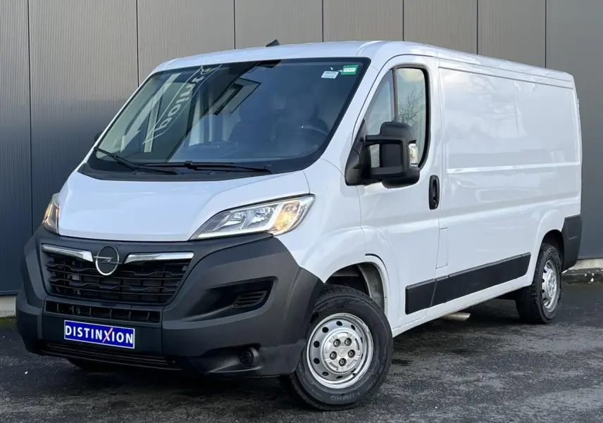 Fourgon Opel Movano blanc vu en 3/4 avant droit, avec calandre noire et rétroviseurs noirs rabattables.