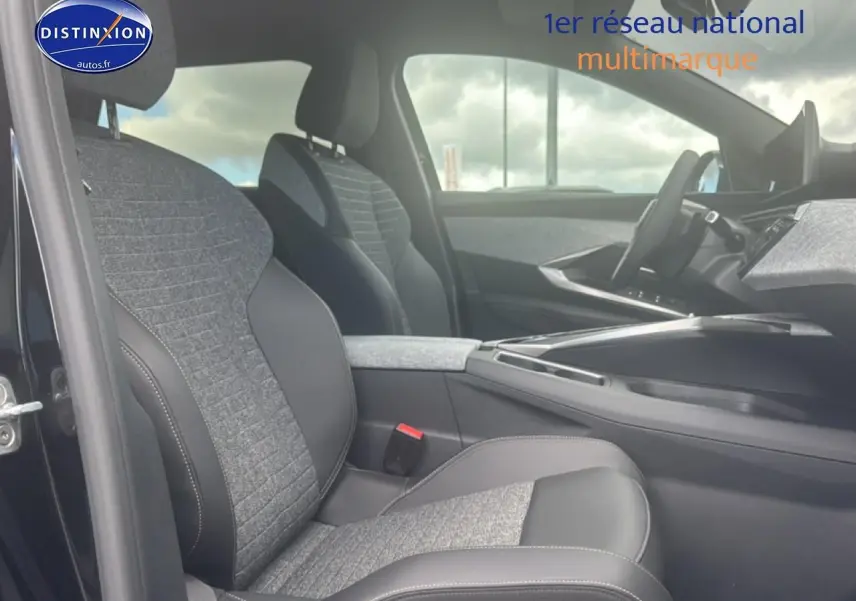 Intérieur de la Peugeot 5008 Hybrid 145 allure e-dcs6 2025, vue côté conducteur sur sièges tissu gris et cuir noir.