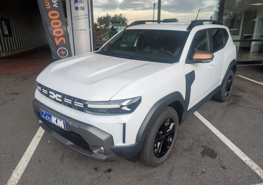 Vue 3/4 avant droite du Dacia Duster Hybrid 155 Extreme blanc glacier avec coques de rétroviseurs brun cuivré et jantes noires 17 pouces.