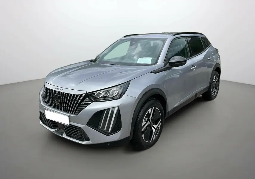 Peugeot 2008 2024 gris artense en 3/4 avant droit, avec calandre noire distinctive et jantes bicolores modernes.