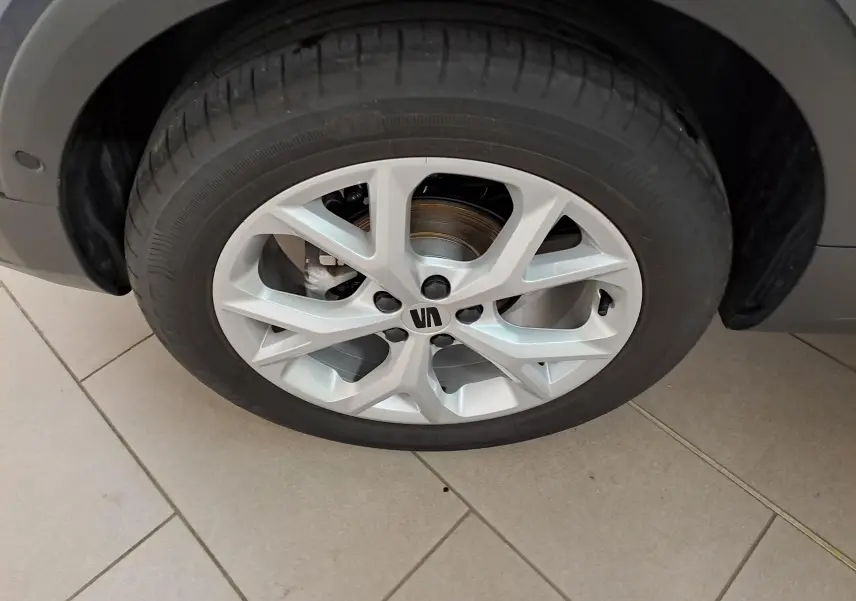 Gros plan sur la roue avant droite du SEAT Arona 2024, jante alliage argentée avec logo central noir.