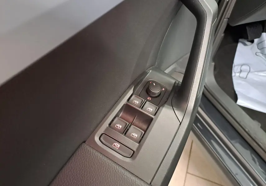 Gros plan sur les commandes des vitres et rétroviseurs côté conducteur du SEAT Arona 2024, intérieur noir.