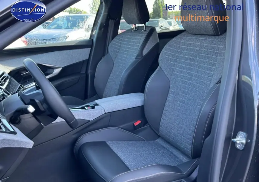 Vue intérieure côté conducteur du Peugeot 5008 gris titane, sièges tissu et cuir avec accoudoir central.