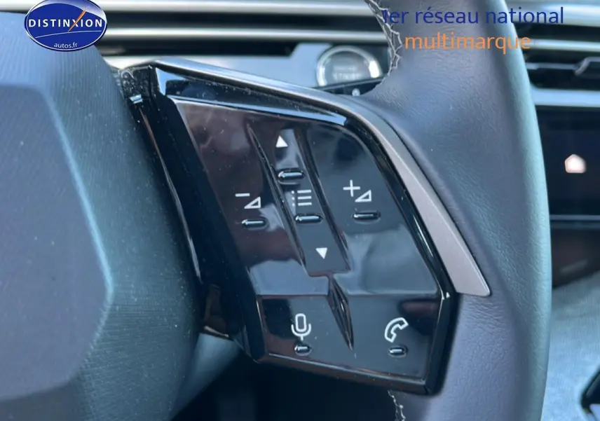 Gros plan sur les commandes vocales et audio au volant cuir du Peugeot 5008 Hybrid 145 allure gris titane, côté gauche.