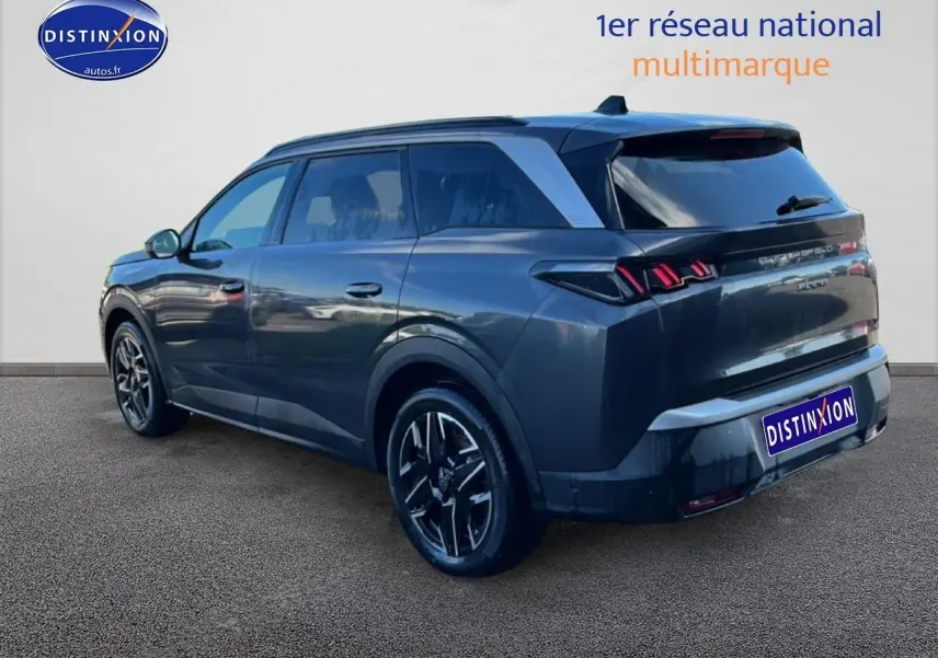 Vue 3/4 arrière droite d’un Peugeot 5008 Hybrid 145 allure gris titane avec jantes alu et feux arrière LED distinctifs.