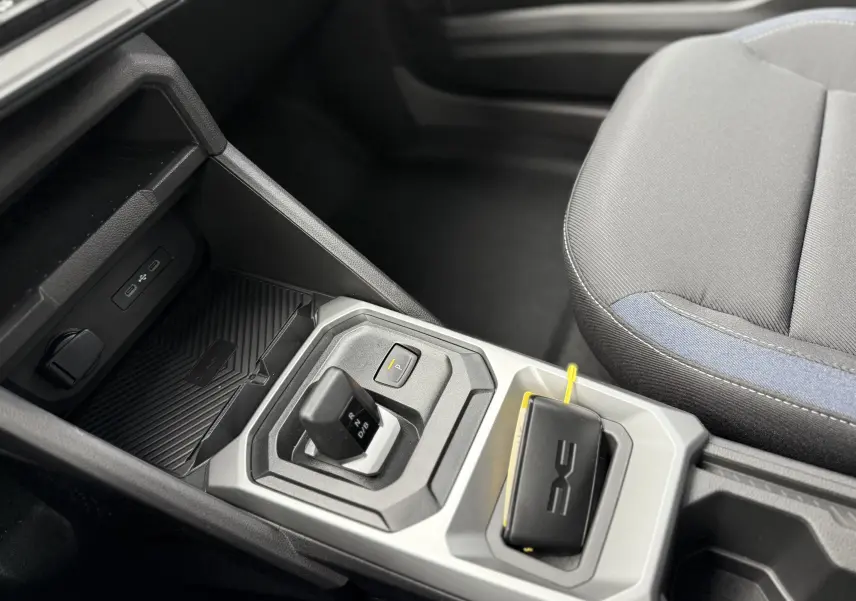 Gros plan sur la console centrale du Dacia Duster 2025 gris schiste, mettant en valeur le levier de boîte automatique et le porte-clés.
