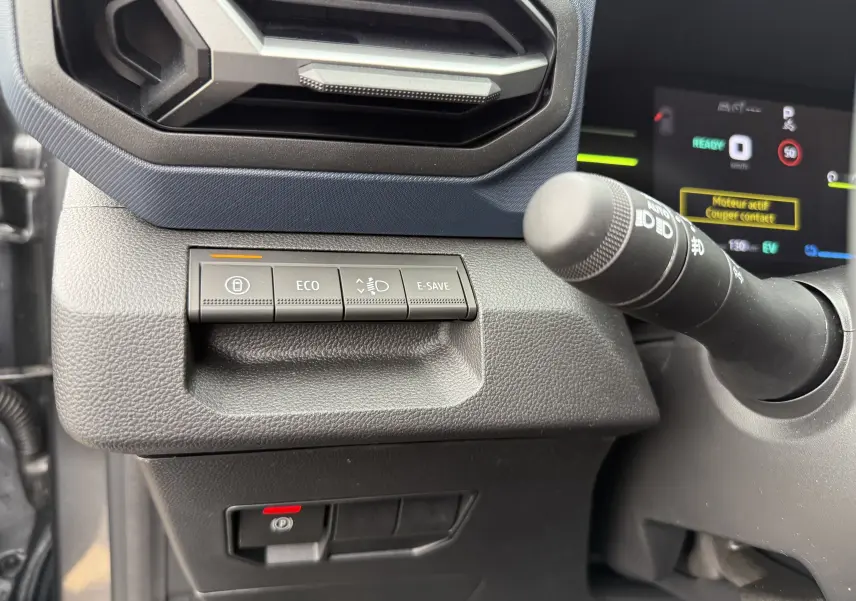 Détail des commandes Eco, E-Save et verrouillage sur tableau de bord gris du Dacia Duster 2025 côté gauche.