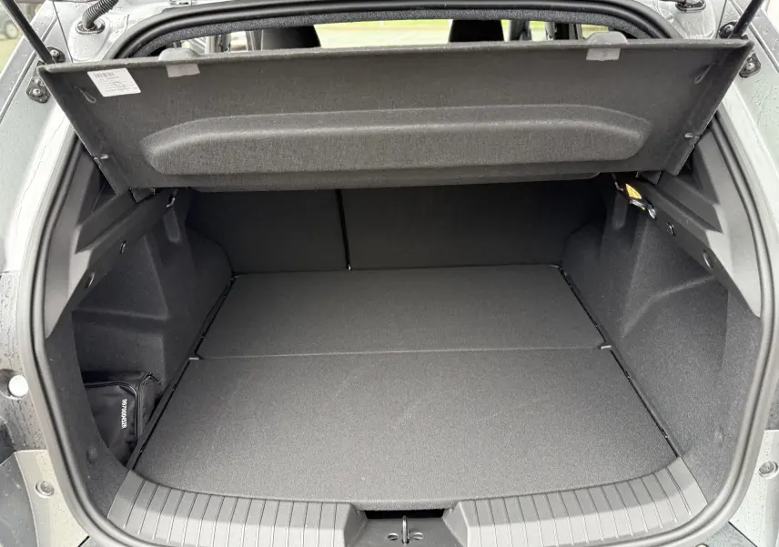 Coffre ouvert du Dacia Duster gris schiste 2025, montrant un espace de chargement propre et spacieux.