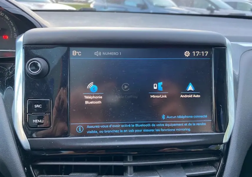 Écran tactile central de la Peugeot 208 gris de 2017 affichant les options Bluetooth et MirrorLink en intérieur.