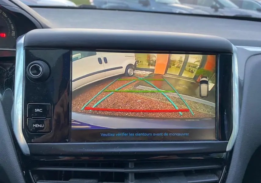 Écran tactile de la Peugeot 208 gris montrant la caméra de recul avec lignes de guidage en arrière-plan.