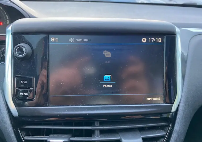 Écran tactile central du tableau de bord de la Peugeot 208 gris, affichant le menu multimédia avec options photos.