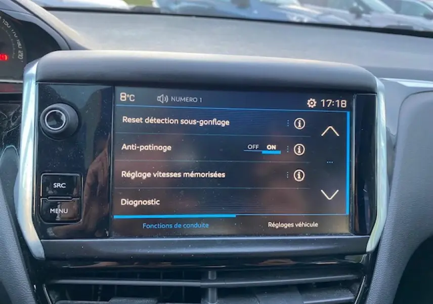Écran tactile central de la Peugeot 208 gris 2017 affichant les réglages d'aide à la conduite.