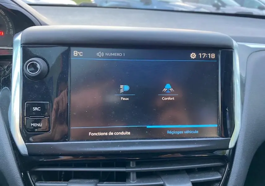 Écran tactile central de la Peugeot 208 gris, affichant les réglages des fonctions de conduite à 17h18.
