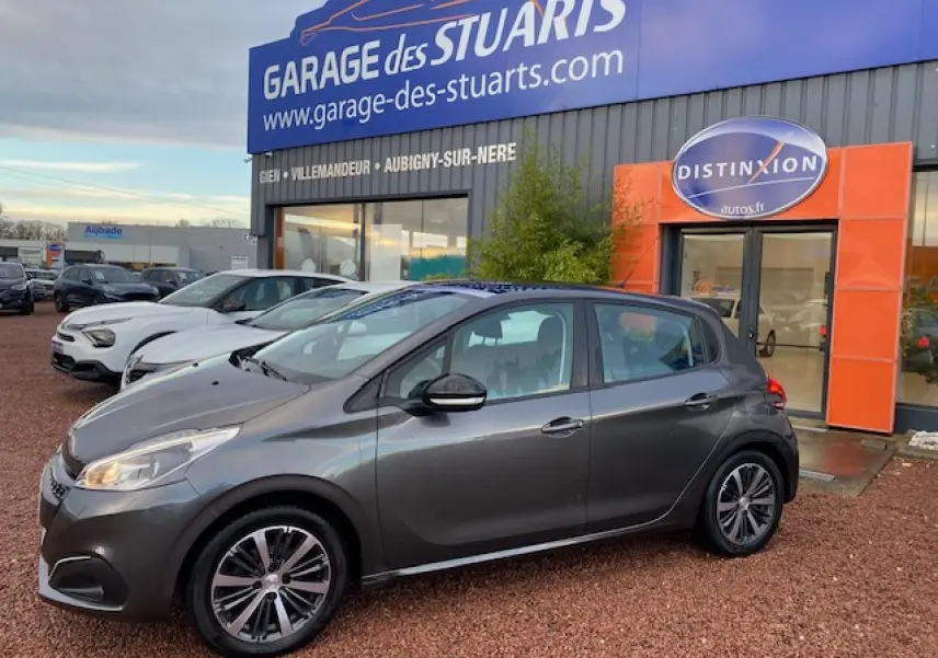 Peugeot 208 gris métallisé vue de profil côté gauche, avec jantes alliage 16 pouces et toit panoramique en verre.