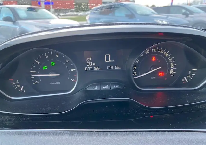 Tableau de bord de Peugeot 208 gris 2017 montrant compte-tours, vitesse à zéro et témoins lumineux allumés.